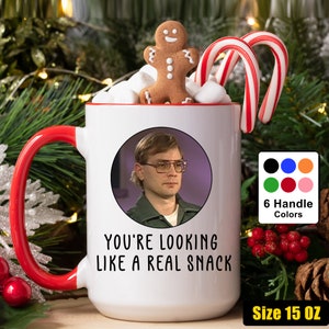 Könnte beinhalten: Eine weiße Keramiktasse mit rotem Henkel. Die Tasse zeigt ein Bild eines Mannes mit Brille und den Text "You're looking like a real snack". Die Tasse hat ein Fassungsvermögen von 15 Unzen.