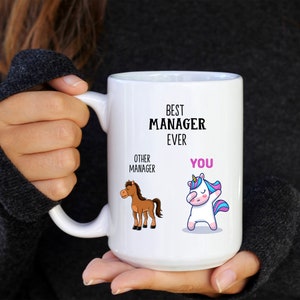 Puede incluir: Taza de cerámica blanca con una ilustración en blanco y negro de un caballo y un unicornio. El texto en la taza dice "Best Manager Ever" y "Other Manager" y "You".