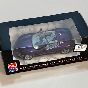 May include: A purple Corvette Sting Ray III concept car model in a black box with a clear window. The car has a detailed interior and silver wheels. The box has the Chevrolet logo and the AMT Ertl logo.