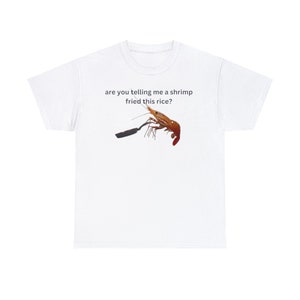 May include: White t-shirt featuring the text "are you telling me a shrimp fried this rice?" and an image of a shrimp in a frying pan.