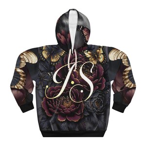 Può includere: Felpa con cappuccio nera con un design floreale e a farfalle. Il design presenta peonie bordeaux, farfalle dorate e le iniziali "JS" in corsivo. La felpa ha un cordino bianco e un orlo nero.