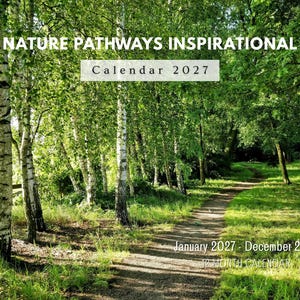 May include: A 2027 wall calendar titled NATURE PATHWAYS INSPIRATIONAL CALENDAR 2027, featuring a photograph of a dirt path winding through a forest of white-barked birch trees and green foliage, covering the period from January 2027 to December 2027.
