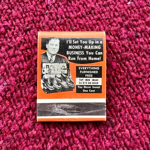 May include: A vintage matchbook advertises a home-based business opportunity. The ad features a man in a suit and tie, and the text reads "I'll Set You Up in a MONEY-MAKING BUSINESS You Can Run From Home! EVERYTHING FURNISHED FREE TOP MEN MAKE $5-$10 AN HOUR You Never Invest One Cent."