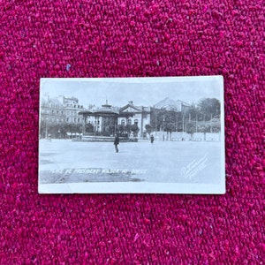 May include: Black and white vintage postcard showing Place de President Wilson in Brest, France. The postcard features a building with a large dome and a sign that reads "Place de President Wilson at Brest".