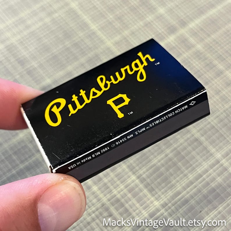 May include: A black matchbox featuring the word "Pittsburgh" in yellow script and a yellow "P" logo. The matchbox is labeled "MATCH COLLECTIBLES" and "Made in USA". The Etsy shop name "MacksVintageVault.etsy.com" is visible.