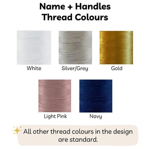 May include: Image showing thread color options: white, silver/grey, gold, light pink, and navy. Text at the top reads "Name + Handles Thread Colours." Below the color swatches, text states "All other thread colours in the design are standard."
