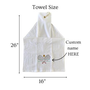 May include: White hanging towel with a tennis-themed embroidered design. The towel measures 26 inches long and 16 inches wide. The design includes tennis rackets, a tennis ball, and the name "TRICIA". The text "Custom name HERE" is also visible.
