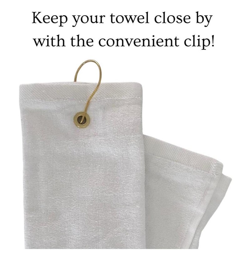 May include: White towel with a gold-colored clip. The towel is folded and has a loop for hanging. Text on the image reads: Keep your towel close by with the convenient clip!