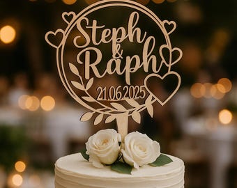 May include: A tiered white wedding cake topped with two white roses and a wooden cake topper. The topper features the names "Steph & Raph" and the date "21.06.2025" in a circular design with hearts and leaves.