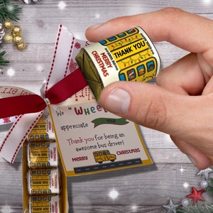 May include: A Christmas gift set for a school bus driver. The gift set includes a small wrapped gift with the text "Merry Christmas" and "Thank You" on it, and a card that says "We appreciate you! Thank you for being an awesome bus driver! Merry Christmas".