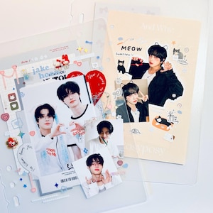 May include: A collection of clear plastic sleeves and photo cards. The photo cards feature images of a person, along with decorative stickers and text. One page has the text "MEOW Sweetness" and "And Why". The theme appears to be related to K-pop.