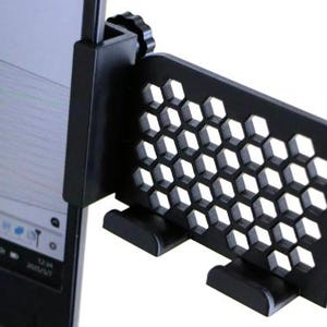 Könnte beinhalten: Ein schwarzer Sichtschutz für Computermonitore mit Wabenmuster. Der Bildschirm wird mit einer Klemme am Monitor befestigt und hat zwei Stützfüße. Der Bildschirm soll verhindern, dass andere den Inhalt des Monitors einsehen können.