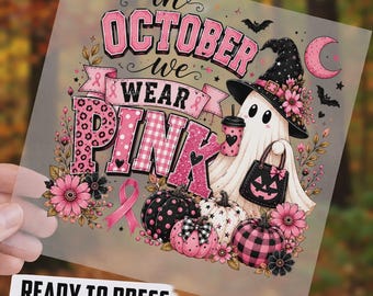 May include: A DTF transfer sheet featuring a ghost wearing a witch hat, holding a coffee cup and a jack-o'-lantern bag. The text reads "IN OCTOBER WE WEAR PINK" with pink pumpkins, flowers, and a breast cancer awareness ribbon design.