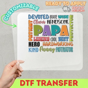 May include: A DTF transfer with the word "PAPA" in large, colorful letters, surrounded by words like "Devoted," "Brave," and "Hero." The design is customizable and ready to apply. The image also includes the text "Ready to Apply" and "Next Day Shipping."