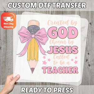 May include: A DTF transfer featuring a pencil with a pink bow and the text "Created by GOD, Chosen by JESUS, Called to be a TEACHER." The design is ready to press and includes the text "READY TO PRESS" and "CUSTOM DTF TRANSFER."