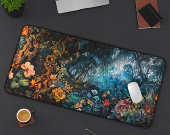 May include: A large, rectangular desk mat featuring a vibrant, colorful floral and forest design. The artwork includes orange, yellow, and blue flowers, with a white computer mouse resting on the mat. A laptop, coffee cup, and pencils are also visible.