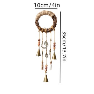 May include: A brown twig wreath with a hanging dream catcher with bells, beads, and charms. The dream catcher is 13.7 inches long and 4 inches wide.