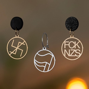 Może przedstawiać: Zestaw trzech ceramicznych kubków z nakrapianym, matowym wykończeniem. Kubki są w odcieniach kremowym, jasnoszarym i ciemnoszarym. Każdy kubek ma prosty, minimalistyczny design.