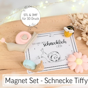 Peut inclure: Un ensemble d'aimants avec un escargot, une abeille et une fleur sur un plateau en bois. L'escargot a une coquille rose et une queue en forme de cœur. L'abeille est jaune et noire. Le set comprend une carte avec le texte "Ich hab dich schnecklich LIEBI".