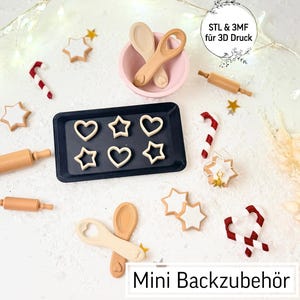 May include: A collection of miniature baking accessories, including rolling pins, spoons, and cookie cutters in heart and star shapes. A black tray holds the cookie cutouts. The image includes the text "Mini Backzubehör" and "STL & 3MF für 3D Druck".