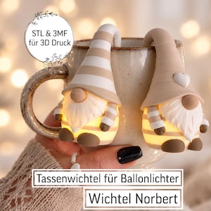 Puede incluir: Dos figuras de gnomos en beige y blanco diseñadas para colgarse del borde de una taza, con cuerpos iluminados, gorros puntiagudos y barbas blancas. El texto en la imagen dice: STL & 3MF für 3D Druck, Tassenwichtel für Ballonlichter y Wichtel Norbert.