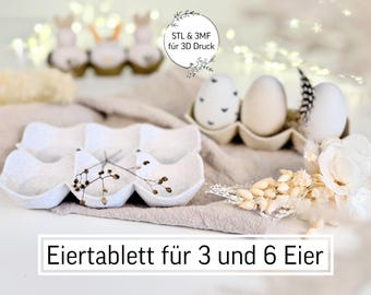 May include: An egg tray for 3 and 6 eggs, with decorative eggs and floral accents. The image includes text that reads "STL & 3MF für 3D Druck". The eggs are in a cardboard egg carton. The overall theme is Easter.