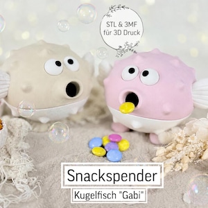 Op de afbeelding: Twee grillige kogelvisvormige snackdispensers, één beige en één roze, met grote ogen en open monden. De dispensers hebben witte vinnen en bases. De afbeelding bevat bubbels, snacks en de tekst "Snackspender KugelFisch 'Gabi'".