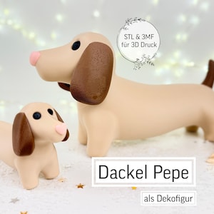 May include: Two beige dachshund dog figurines, one large and one small, with brown ears and tails, and pink noses. The larger dog stands behind the smaller one. Text on the image reads "Dackel Pepe als Dekofigur" and "STL & 3MF für 3D Druck".