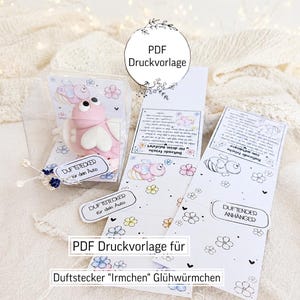May include: A pink clay firefly figurine with large eyes and white wings inside a clear plastic box, accompanied by two printed paper templates featuring illustrations of fireflies and flowers with the text PDF Druckvorlage.