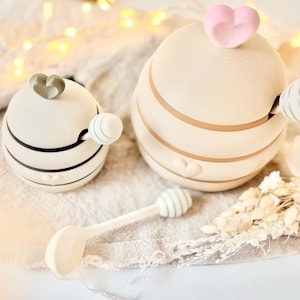 May include: A set of three ceramic mugs with a speckled, matte finish. The mugs are in shades of cream, light gray, and dark gray. Each mug has a simple, minimalist design, perfect for coffee or tea.