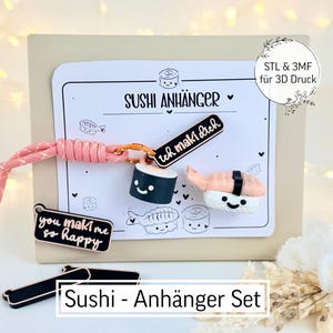 Puede incluir: Un juego de colgantes con temática de sushi que incluye un cordón rosa, colgantes con forma de sushi y una tarjeta con ilustraciones de sushi. Los colgantes incluyen un maki, un nigiri y una etiqueta negra que dice "you maki me so happy".