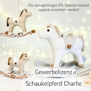 May include: Three toy rocking horses in cream and tan colors. The horses have a saddle with a heart-shaped detail. The text on the image says "Gewerbelizenz" and "Schaukelpferd Charlie". The text at the top says "Die dazugehörigen STL Dateien müssen separat erworben werden!"