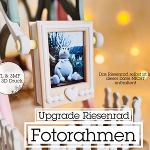 May include: A decorative photo frame with a picture of a cartoon deer. The frame is light pink and white, with a heart-shaped embellishment. Text on the frame reads "Upgrade Riesenrad Fotorahmen".