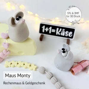 Può includere: Sono esposte due statuette di topi grigi con grandi occhi neri e nasi rosa. Un topo è seduto su una forma di formaggio giallo, collegato a perline rosa a forma di cuore. Una piccola lavagna recita "1+1=Käse". È visibile anche il testo "Maus Monty" e "Rechenmaus & Geldgeschenk".