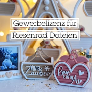 May include: A festive display featuring a Ferris wheel, a framed picture of a blue character, a wooden sign with "Winter Zauber", and a heart-shaped decoration with "Love is in the Air". The text "Gewerbelizenz für Riesenrad Dateien" is also present.