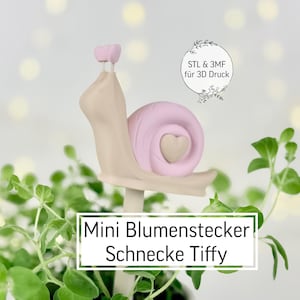 Könnte beinhalten: Ein skurriler Gartenstecker in Form einer Schnecke. Die Schnecke hat ein rosa Gehäuse mit einem Herz, einen beigen Körper und einen rosa Kopf. Der Text "Mini Blumenstecker Schnecke Tiffy" ist auf dem Stecker abgebildet.