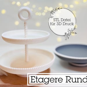 Pode incluir: Um suporte branco de dois níveis com borda de contas e suporte central. Um prato cinza para servir está ao lado do suporte. A imagem inclui o texto "STL Datei für 3D Druck" e "Etage Rund".