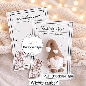 Könnte beinhalten: Ein braun-weißer Wichtelmagnet auf einer rechteckigen Karte mit dem Text Wichtelzauber und Magnet für wichtige Botschaften, daneben eine passende Karte mit einer Wichtelillustration und dem Text PDF Druckvorlage.