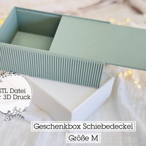 May include: A light green sliding lid box with a textured, ribbed front. The box is open, revealing the interior. The box sits on a white box. Text on the image reads "STL File for 3D Print" and "Gift Box Sliding Lid Size M".