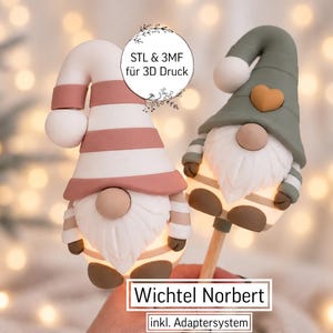 May include: Two gnome figures for 3D printing, labelled Wichtel Norbert. One gnome wears a pink and white striped hat, the other a sage green hat with a heart. Both have white beards, round noses, and brown accents. Includes text STL & 3MF für 3D Druck.