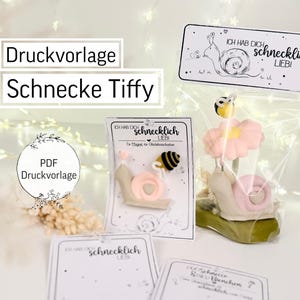 Peut inclure: Divers cadeaux et imprimables sur le thème de l'escargot. L'image présente une figurine d'escargot avec une coquille rose, une abeille et une fleur. Le texte comprend "Druckvorlage Schnecke Tiffy" et "PDF Druckvorlage". D'autres cartes indiquent "Ich hab dich schnecklich LIEBI".