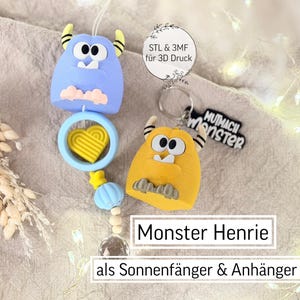 Puede incluir: Un conjunto de atrapasoles y llaveros con temática de monstruos azules y amarillos. El conjunto incluye dos figuras de monstruos, un dije en forma de corazón y un llavero con el texto "Mutmach Monster". También es visible el texto "Monster Henrie".