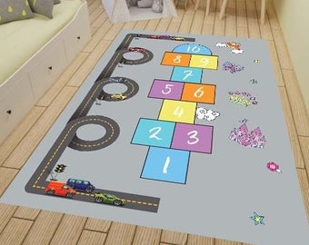 May include: A grey play mat with a hopscotch game and a road with cars. The numbers 1 to 10 are on the hopscotch squares. The road has a circle at the end.