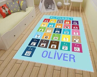 May include: A light blue alphabet rug with colorful squares featuring letters of the alphabet and a picture for each letter. The rug has the name "OLIVER" printed in blue at the bottom.