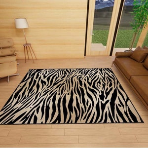 May include: A black and white zebra print area rug with a brown leather sofa and a wooden chair in the background.