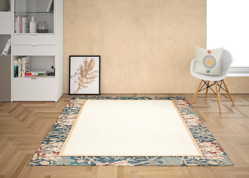 Puede incluir: Una alfombra beige con un borde floral azul, verde y rojo. La alfombra tiene un centro blanco y un borde beige alrededor del centro.
