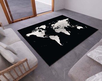 May include: A black and white world map rug with a white outline of the continents on a black background. The rug is in a living room setting with two couches.