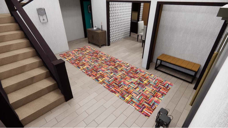 May include: A rectangular runner rug featuring a vibrant, multi-colored pattern of stacked books in shades of red, blue, yellow, and orange. The rug is positioned on a light-colored floor in a hallway, displaying a dense, repeating book spine design.