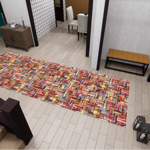 May include: A rectangular area rug featuring a vibrant, multi-colored patchwork design with a woven texture. The rug displays a complex pattern of small, interlocking fabric strips in shades of red, yellow, blue, orange, and purple, creating a dense, colorful visual effect across the entire surface.