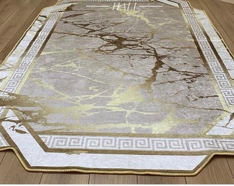 May include: A white rug with a gold and brown marble pattern. The rug has a decorative border with a Greek key design.